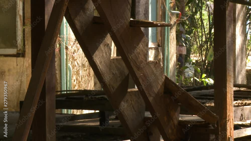 A daylight closeup shot of a broken staircase from an old stilted house showing the remaining two carriage support and unsafe wooden steps. A daylight closeup shot of a broken staircase from an old stilted house showing the remaining two carriage support and unsafe wooden steps.