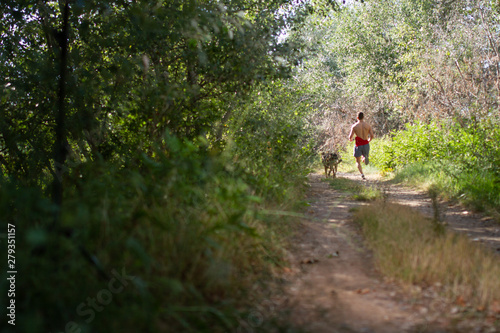 runner running across the field with his dog