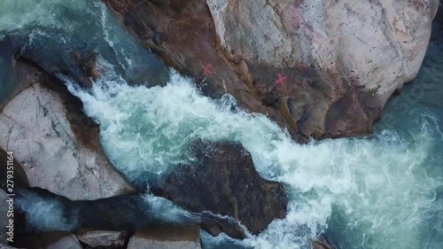 Flying on the drone above the wild waterfall in tropical palm forest. Beautiful landscape of green jungle and stream of mountain river. Cascade of water around nature. Travel concept in Asia.
