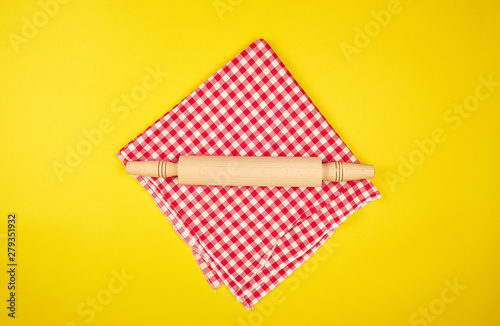new wooden rolling pin on a red textile napkin
