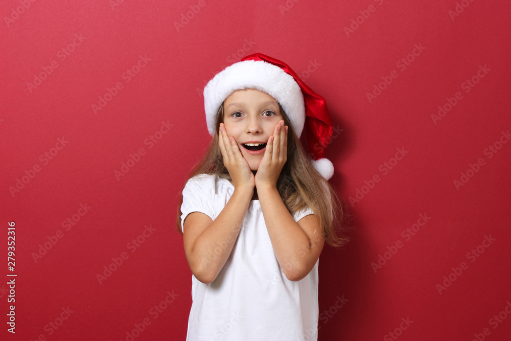 cheerful girl on a colored background in the Christmas hat cheerful girl on a colored background in the Christmas hat