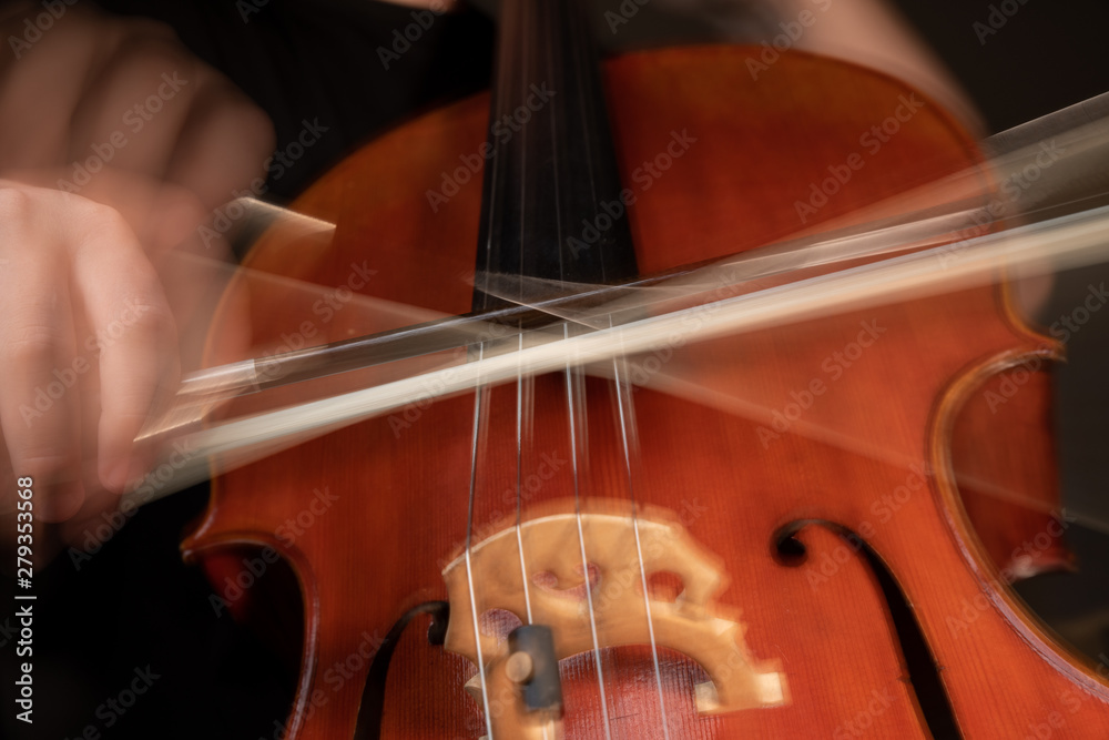 A young cellist practices intensely in this close up high resolution photo of strings, cello, and bow A young cellist practices intensely in this close up high resolution photo of strings, cello, and bow