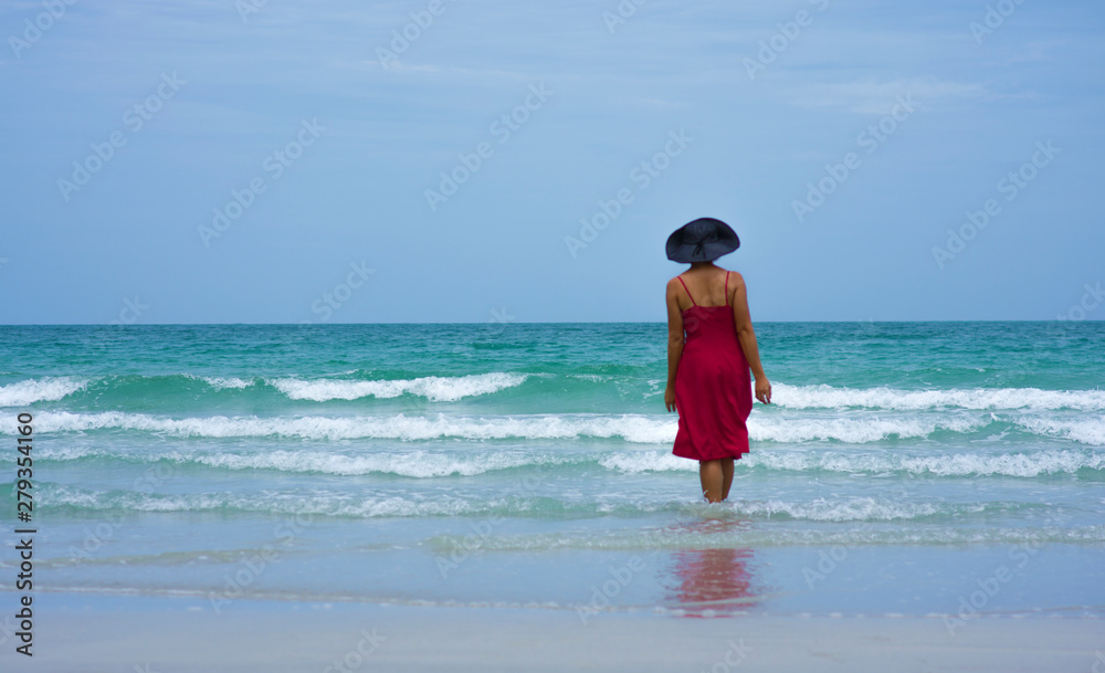Women in red dress invite to visit the beautiful sea in Thailand.