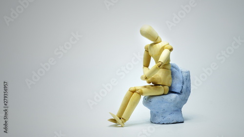 The gesture of a wooden puppet showing abdominal pain at the time of excretion