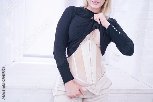 фотографія beautiful girl with plus size figure shows hidden under normal clothes training
