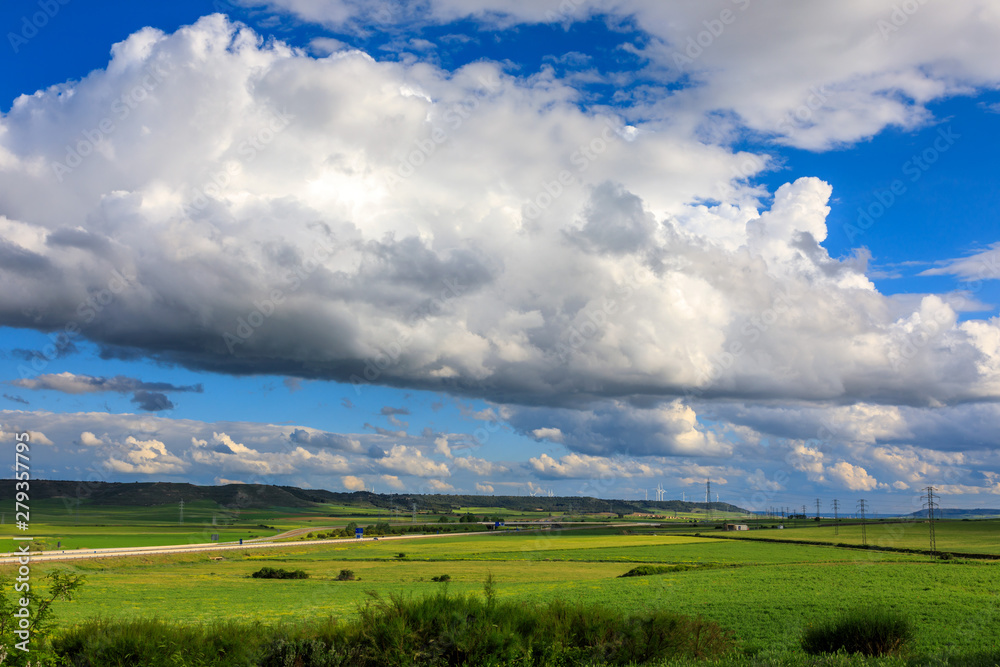 Spring landscape, green fields of wheat and clouds over blue sky. Sunny day. Spring landscape, green fields of wheat and clouds over blue sky. Sunny day.