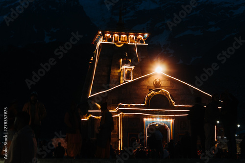 View of the Kedarnath temple lights at night with mountains in the background in Uttarakhand, India photo