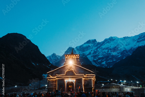 View of the Kedarnath temple lights at night with mountains in the background in Uttarakhand, India photo