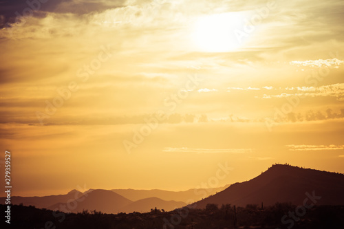 A sunset over a distant mountain in the Sonoran Desert of Arizona