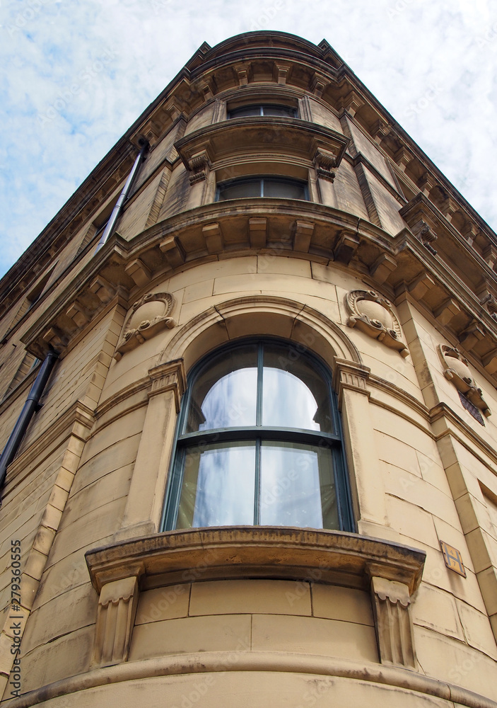 perspective view of a 19th century tall stone neoclassical building with ornate curved windows in the little germany business district of bradford west yorkshire perspective view of a 19th century tall stone neoclassical building with ornate curved windows in the little germany business district of bradford west yorkshire