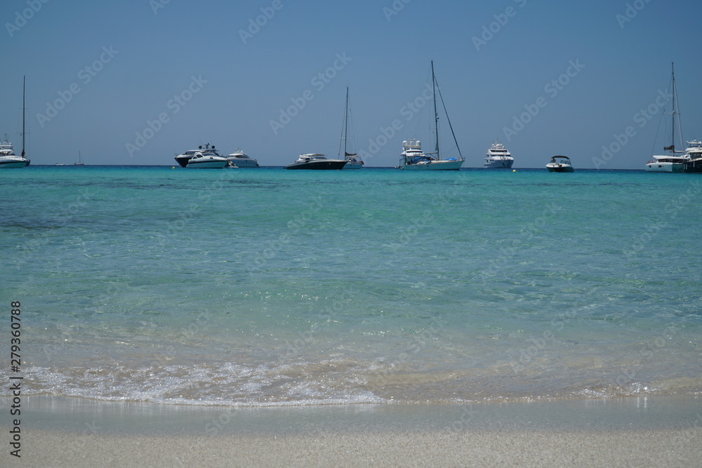 Yachten und Katamaran im karibischen Meer am Horizont im klaren türkisen Wasser