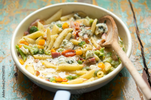 Pasta with vegetables and cheese sauce. Pasta with bacon, yellow peppers, broccoli, tomatoes and blue cheese 
