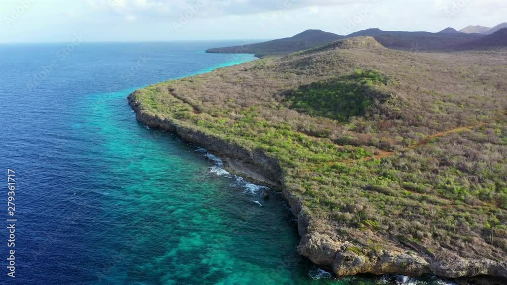 Aerial view of coast of Curaçao in the Caribbean Sea with turquoise water, cliff, beach and beautiful coral reef around the Sta. Martha Bay