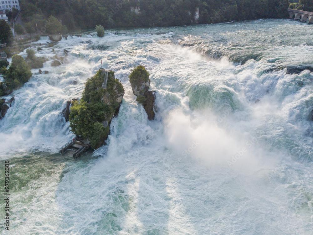 Aerial view of rocks in Rhine falls water cascade near Schaffhausen with swiss flag in Switzerland Aerial view of rocks in Rhine falls water cascade near Schaffhausen with swiss flag in Switzerland