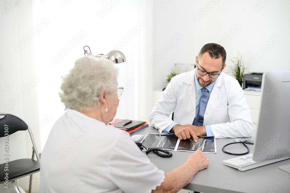 Obraz premium handsome doctor giving medical consultation diagnostic to elderly senior woman in hospital office