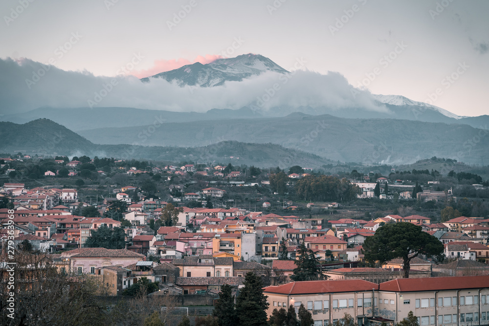 Magnificent view of the Volcano Etna at sunset. The clouds caressing the mountain