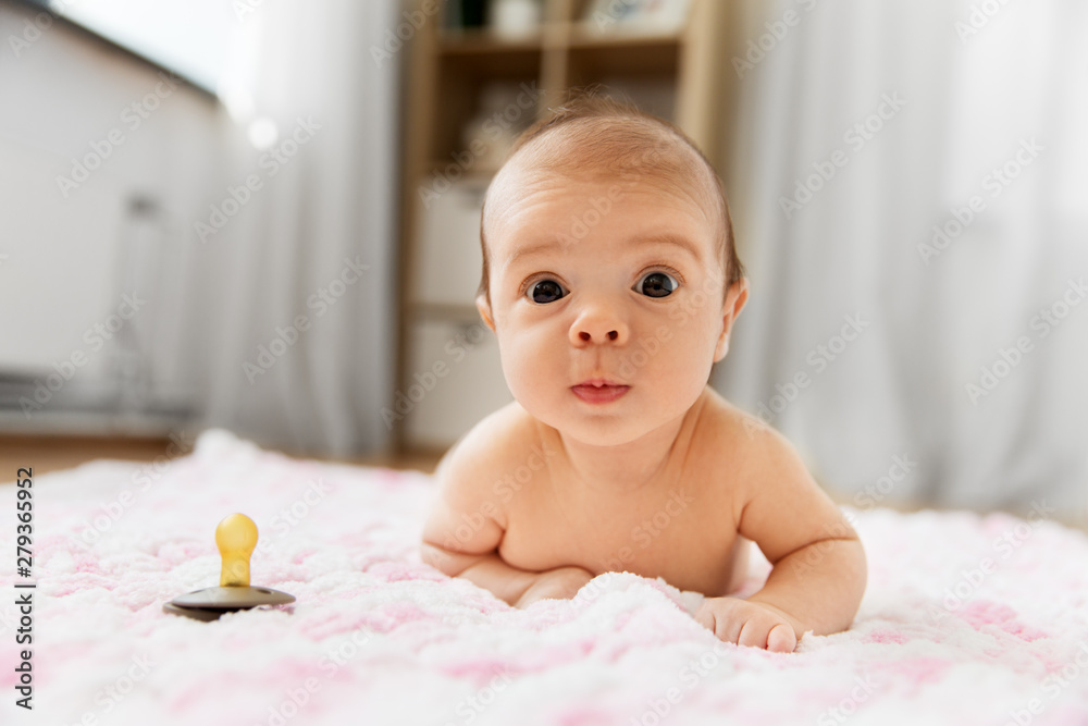 babyhood and people concept - sweet little baby girl in diaper lying ...