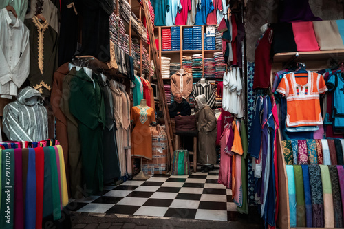 Men discussing in a shop for clothes and fabrics in the center of Marrakech, Morocco