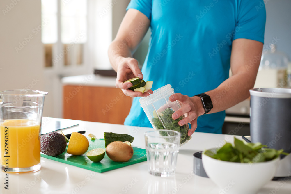 Close Up Of Man Preparing Ingredients For Healthy Juice Drink After Exercise - obrazy, fototapety, plakaty 