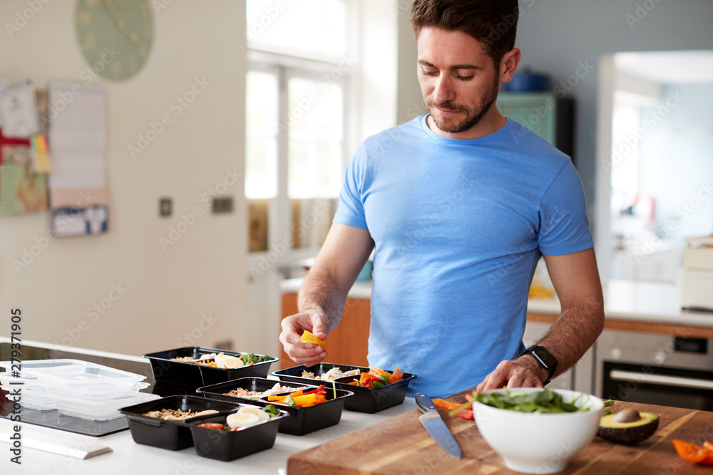 Man Preparing Batch Of Healthy Meals At Home In Kitchen - obrazy, fototapety, plakaty 