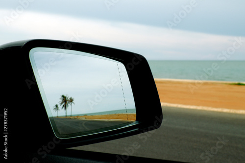 shot of mirror  driving along the beach © YH