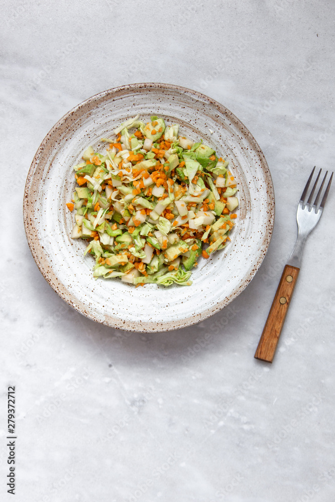 Coleslaw of cabbage, carrots and various herbs with mayonnaise in a large plate on a marble background with copy space Coleslaw of cabbage, carrots and various herbs with mayonnaise in a large plate on a marble background with copy space