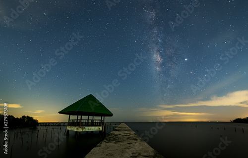Fototapeta Naklejka Na Ścianę i Meble -  The Milky Way on the night sky with the light reflected from the city lights. The Mangrove forests that only stump. The sea of ​​Samut Sakhon.