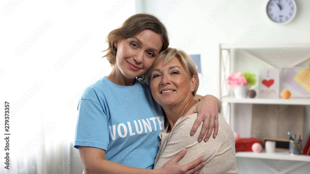 Volunteer hugging old lady, pensioners assistance, support program and charity Volunteer hugging old lady, pensioners assistance, support program and charity