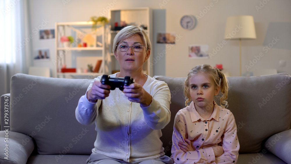 Φωτογραφία Upset girl looking at granny playing videogame, lack of attention, offence