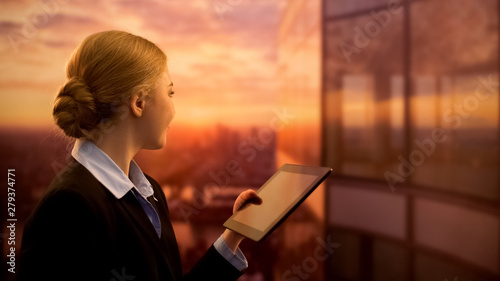 Pretty female choosing sea cruise, looking at sunset and dreaming of vacation