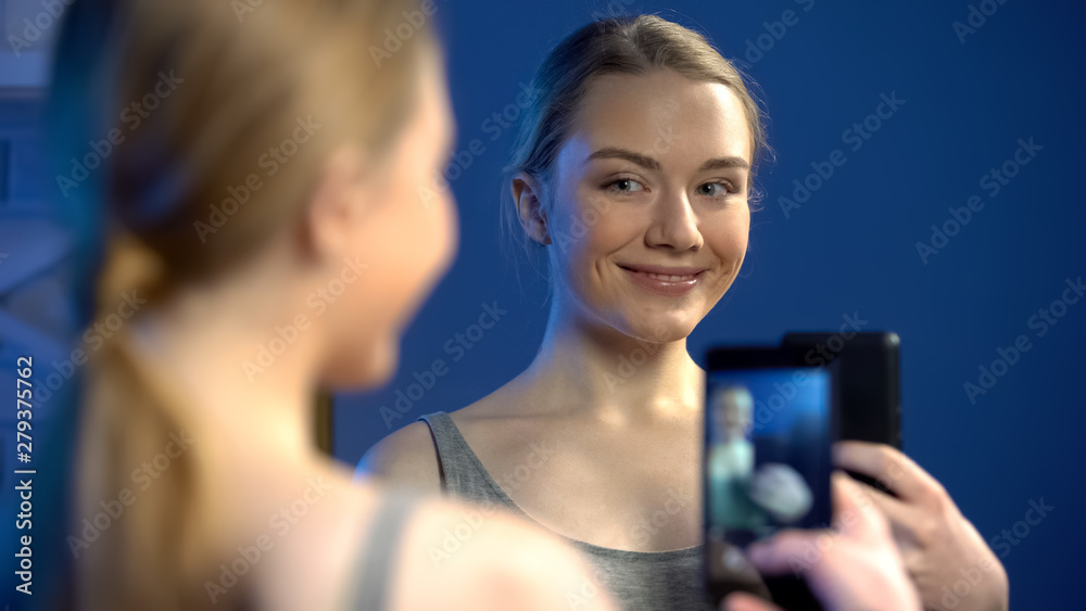 Beautiful young lady making selfie in mirror reflection for social nets, fun Beautiful young lady making selfie in mirror reflection for social nets, fun