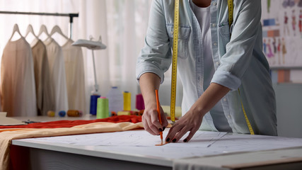 Clothes designer drawing patterns from clients size, workshop for making clothes