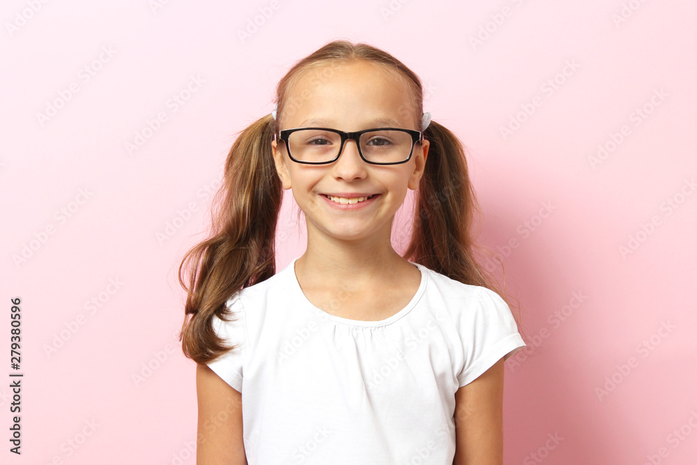 Portrait of a cute smiling girl in glasses on a color background.