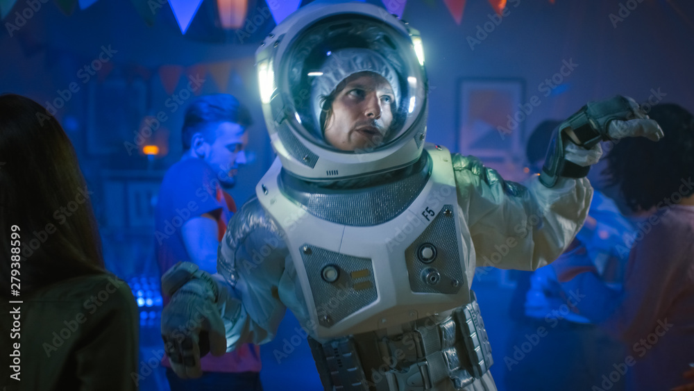 At the College House Costume Party: Fun Guy Wearing Space Suit Dances Off, Doing Robot Dance Modern Moves. With Him Beautiful Girls and Boys Dancing in Neon Lights. At the College House Costume Party: Fun Guy Wearing Space Suit Dances Off, Doing Robot Dance Modern Moves. With Him Beautiful Girls and Boys Dancing in Neon Lights.
