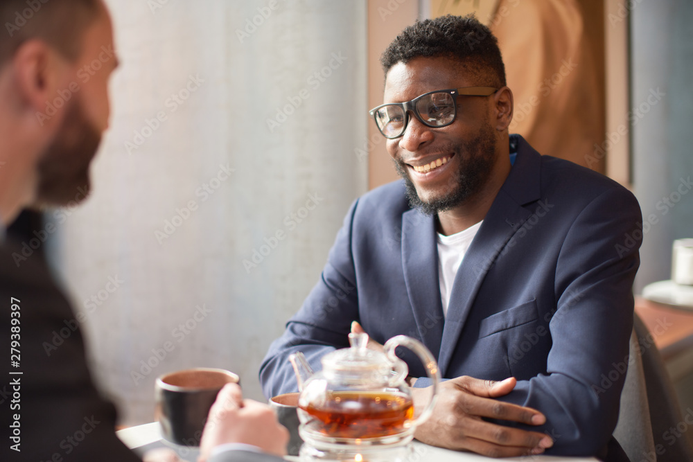 Two businessmen having an enjoyable conversation with a cup of tea.