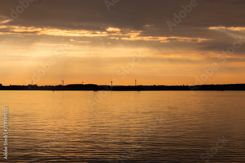 Beautiful sunset at the sea called Kattegat, with windmills in the background © Hulshofpictures