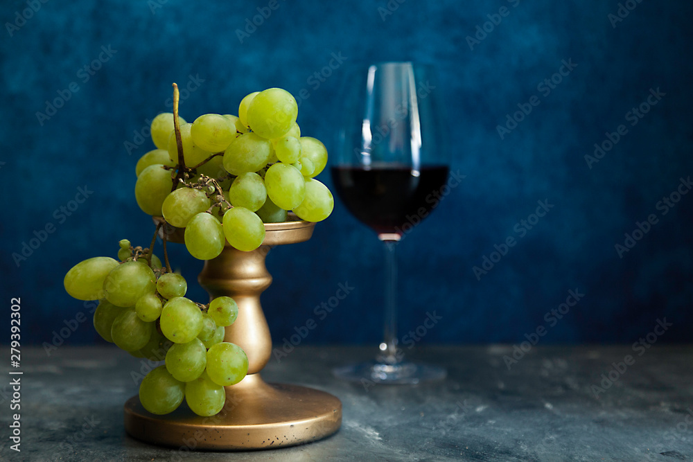 bunch of white grapes and defocused red wine glass bunch of white grapes and defocused red wine glass
