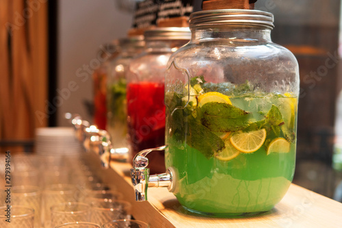 Various lemonade at the bar in jars with tap photo