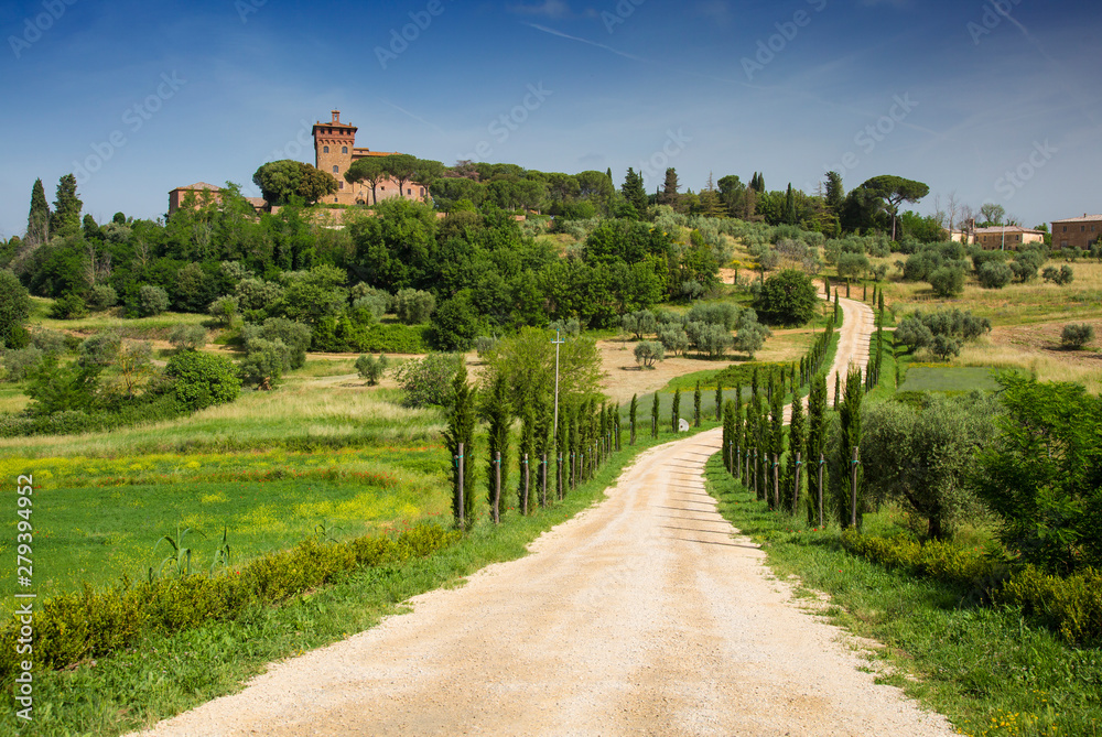 Beautiful landscape in Tuscany with road, castle and cypress trees, Italy.