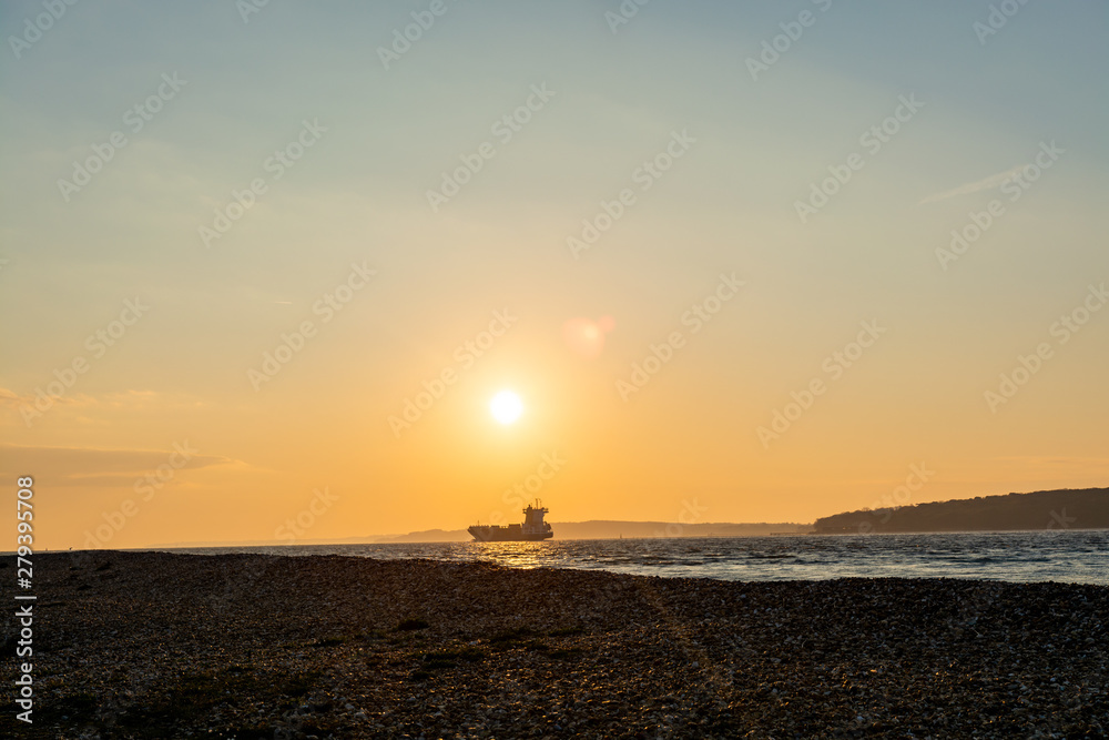 Landscape of a bay with tanker coming in to the port during sunrise