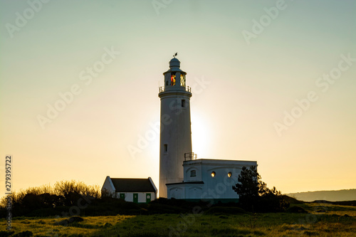 Hurst Point Lighthouse during sunrise with sun directly behind the tower, England