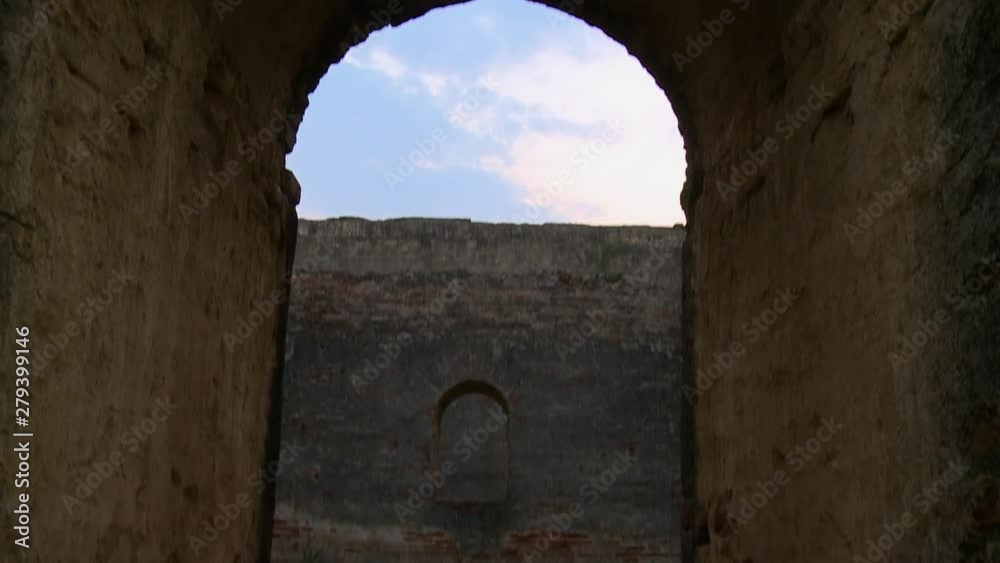 A hand held, tilting, medium shot of a huge door that takes you in the middle of history from a forgotten fortress. A hand held, tilting, medium shot of a huge door that takes you in the middle of history from a forgotten fortress.