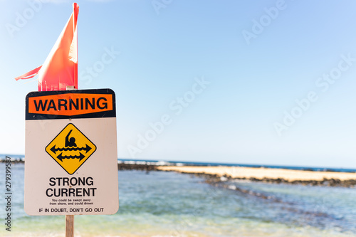 Sign warning about strong current on beach