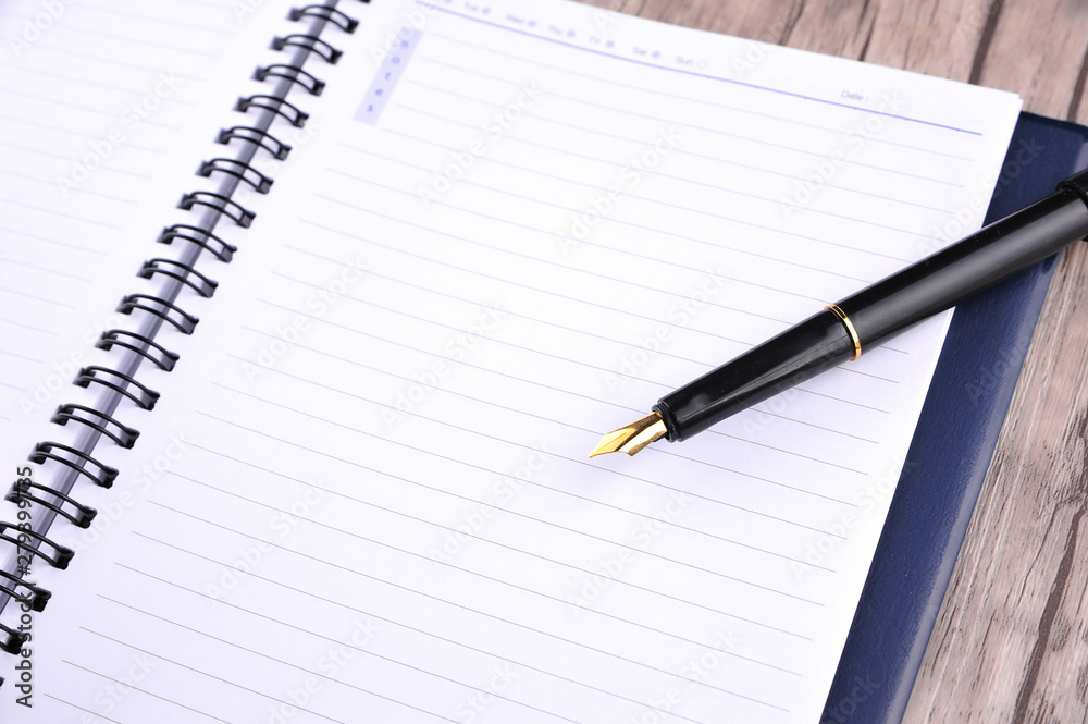 Notebook with fountain pen on wooden table Notebook with fountain pen on wooden table
