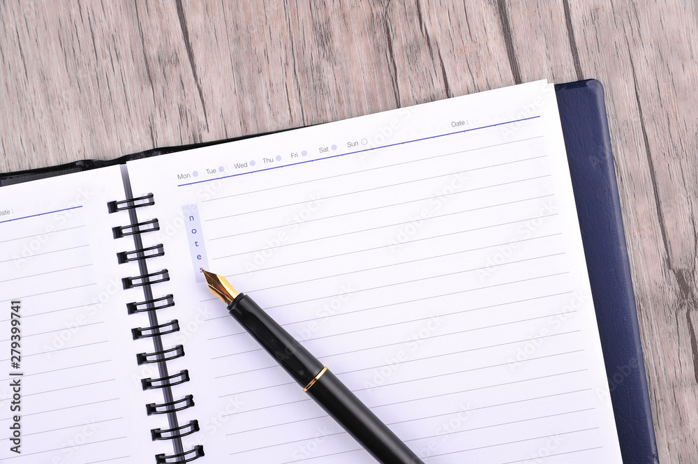 Notebook with fountain pen on wooden table Notebook with fountain pen on wooden table