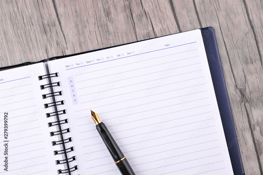 Notebook with fountain pen on wooden table Notebook with fountain pen on wooden table
