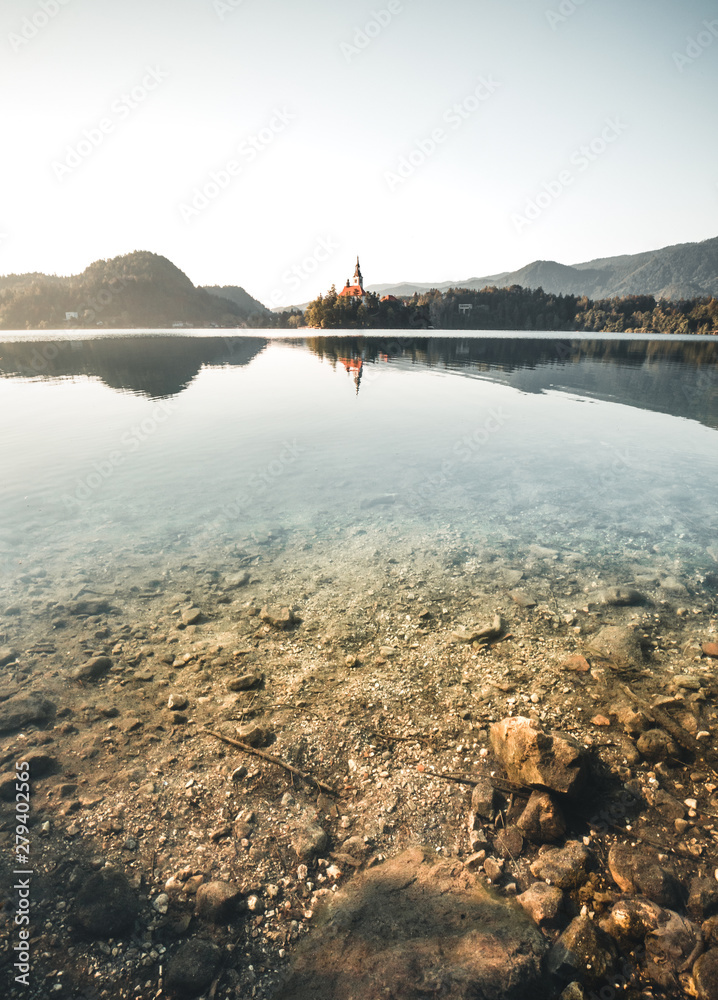 First light of sunrise on silhouette tower of Assumption of Mary church at Lake Bled.