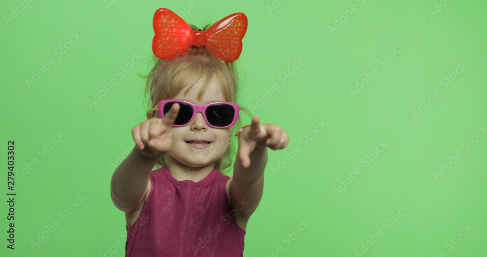 Positive girl in purple dress shows a finger forward to camera. Chroma Key