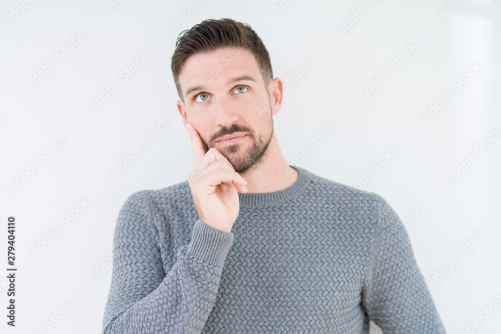 Young handsome man wearing casual sweater over isolated background with hand on chin thinking about question, pensive expression. Smiling with thoughtful face. Doubt concept. Young handsome man wearing casual sweater over isolated background with hand on chin thinking about question, pensive expression. Smiling with thoughtful face. Doubt concept.