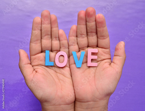 Hand holding letter blocks "LOVE"